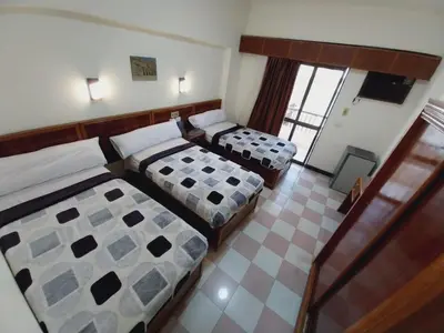 a hotel room with two beds and a balcony at Merry Land Hotel & Roof Top Nile Restaurant Luxor in Luxor