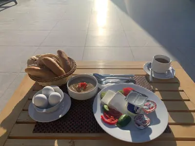 a table with a plate of food and eggs on it at Lazur Sea & City Apartment's - El Hadaba, Hurghada - Egypt in Hurghada