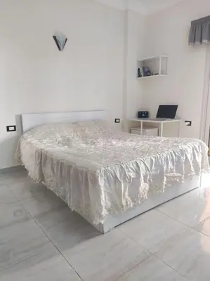 a white bed in a white bedroom with a white floor at Studio Cleopatra Resort in Hurghada