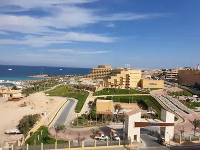 a view of a beach with buildings and the ocean at Studio Cleopatra Resort in Hurghada