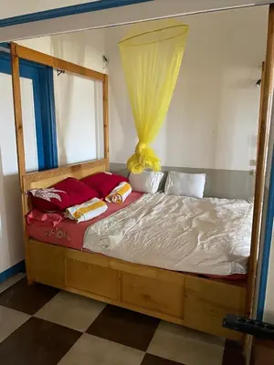 a wooden bed with a canopy in a room at Das Haus am Meer in Safaga