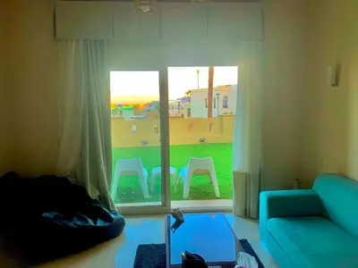 a living room with a blue couch and a window at Azzura appartment sahl hashesh with private garden in Hurghada