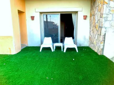 two white chairs sitting on a yard of green grass at Azzura appartment sahl hashesh with private garden in Hurghada