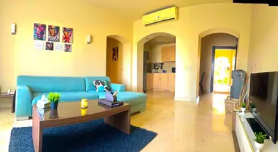 a living room with a blue couch and a table at Azzura appartment sahl hashesh with private garden in Hurghada