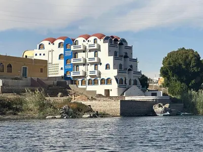 a large white building next to a body of water at ACHERTOD Nubian House in Naj‘ al Maḩaţţah