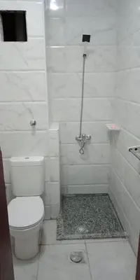 a white bathroom with a toilet and a shower at Tibaview in Hurghada