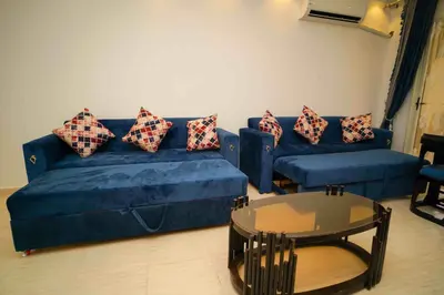 a living room with a blue couch and a table at كمباوند فلورنزا خمسين in Hurghada