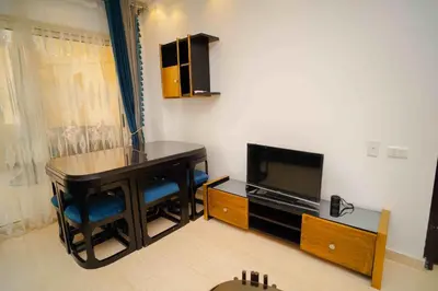 a living room with a table and a television at كمباوند فلورنزا خمسين in Hurghada
