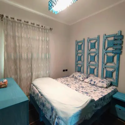 a bedroom with a bed with a blue head board at Royal Beach G 05 in Hurghada