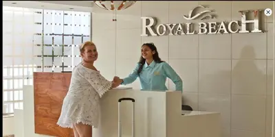 a woman shaking hands with a woman at a counter at Royal Beach G 05 in Hurghada