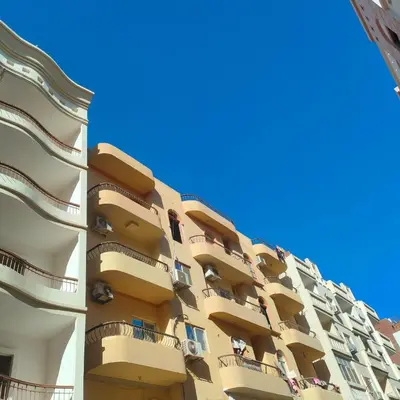 a tall apartment building with balconies and a blue sky at Hurghada City Apartment 3 in Hurghada