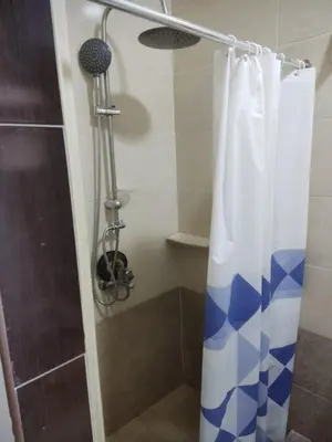 a shower with a blue and white shower curtain at Hurghada City Apartment 3 in Hurghada