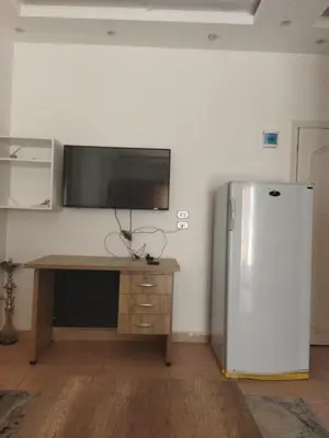 a refrigerator in a room with a desk and a tv at Hurghada City Apartment 3 in Hurghada