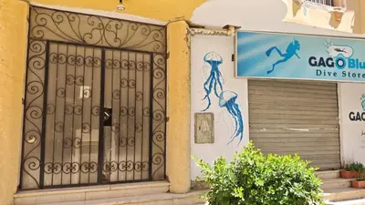 a door to a dive store with a sign on a building at Hurghada City Apartment 3 in Hurghada