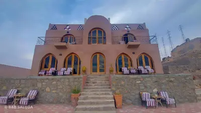 a building with a bunch of chairs in front of it at Saluga Nubian Guest House in Aswan