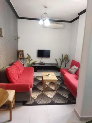 a living room with two red couches and a tv at Hurghada City Apartment1 in Hurghada