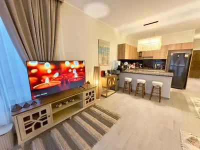 a living room with a flat screen tv and a kitchen at Luxury Villa Bali Al Gouna Hurgh in Hurghada