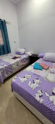 a room with two beds with winnie the pooh sheets at Ahmed House 1 in Safaga
