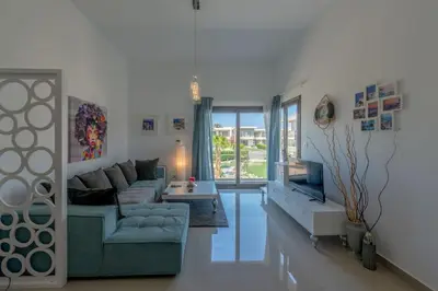 a living room with a couch and a tv at Gcribs apartment pool view in El Gouna