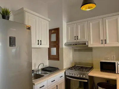 a kitchen with white cabinets and a stove top oven at Artsy 1 BR Apt/ Free Pool & Lagoon Access @ElGouna in Hurghada