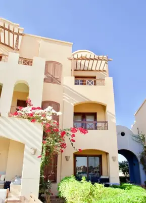 a white building with flowers in front of it at Artsy 1 BR Apt/ Free Pool & Lagoon Access @ElGouna in Hurghada