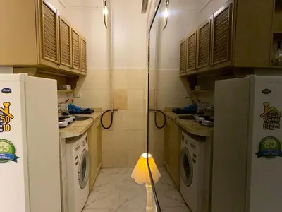 a kitchen with two washing machines and a refrigerator at Уютная квартира в светлых тонах рядом с легендарной улицей Шератон в центре in Hurghada
