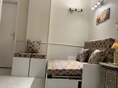 a room with a bed and two chairs in it at Уютная квартира в светлых тонах рядом с легендарной улицей Шератон в центре in Hurghada