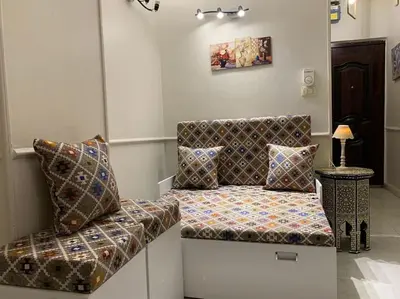 a couch with pillows on it in a room at Уютная квартира в светлых тонах рядом с легендарной улицей Шератон в центре in Hurghada