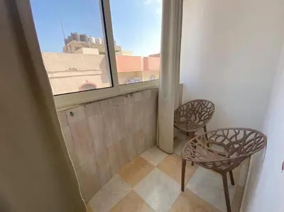 a balcony with two chairs and a window at Уютная квартира в светлых тонах рядом с легендарной улицей Шератон в центре in Hurghada