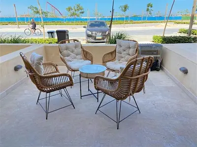 a group of rattan chairs and a table and a car at Glamorous 2BR/ Free Beach & Pool Access @ Mangroovy, El Gouna in Hurghada