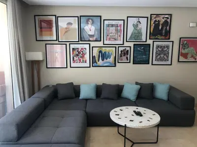 a living room with a blue couch and pictures on the wall at Glamorous 2BR/ Free Beach & Pool Access @ Mangroovy, El Gouna in Hurghada