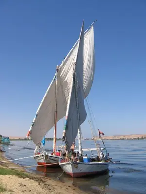 two boats with a white sail in the water at SmSm Kato in Aswan