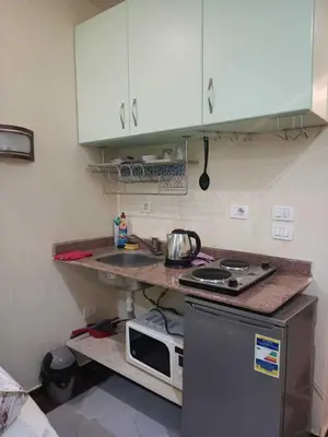 a small kitchen with a sink and a microwave at Harmony Sunny Chalet With Wi-Fi in Hurghada