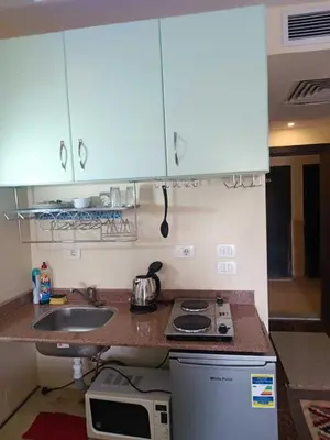 a kitchen with a sink and a stove and cabinets at Harmony Sunny Chalet With Wi-Fi in Hurghada