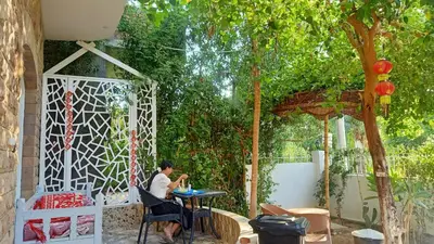 a person sitting at a table in a garden at Dream Garden Luxor in Luxor