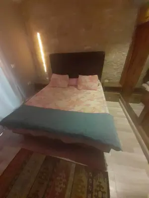 a small bedroom with a bed with pink pillows at FeWo Port Ghalib in Port Ghalib
