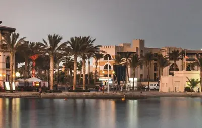 a large body of water with palm trees and buildings at FeWo Port Ghalib in Port Ghalib