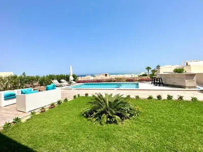 a backyard with a swimming pool and a yard with grass at The view compound in Hurghada