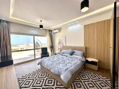 a bedroom with a large bed and a large window at The view compound in Hurghada