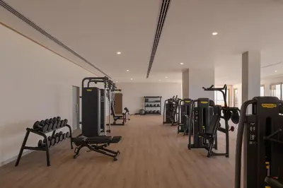 a gym with a row of treadmills and machines at JAZ Elite Asteria in Hurghada