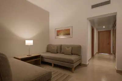 a living room with a couch and a chair at JAZ Elite Asteria in Hurghada