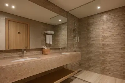 a bathroom with two sinks and a mirror at JAZ Elite Asteria in Hurghada