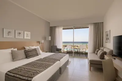 a hotel room with a large bed and a television at JAZ Elite Asteria in Hurghada