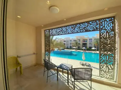 a room with a large window with a view of a pool at Stunning 2 BR/ Free Beach & Pool Access @ Mangroovy, El Gouna in Hurghada
