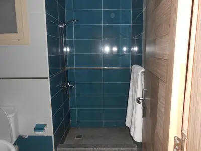 a bathroom with a shower with blue tiles at Fox House Beach Resort & Spa El Gouna in Hurghada