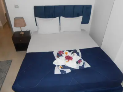 a bed with a blue and white comforter and flowers on it at Fox House Beach Resort & Spa El Gouna in Hurghada