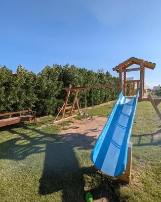a playground with a blue slide in the grass at Fox House Beach Resort & Spa El Gouna in Hurghada