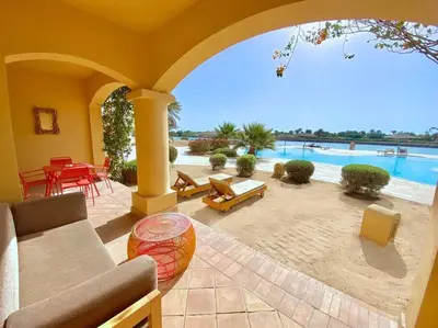 a living room with a patio with a pool at Magical 2BR Ground/Free Pool & Lagoon Access @ElGouna in Hurghada