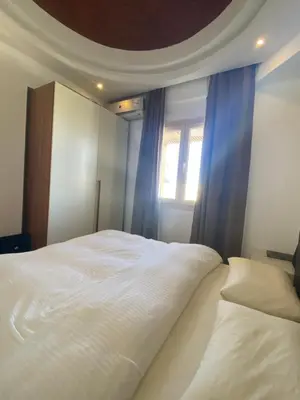 a white bed in a room with a window at Makadi heights luxury apartment in Hurghada