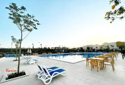 a swimming pool with chairs and a table and a table and chairsitures at Makadi heights luxury apartment in Hurghada